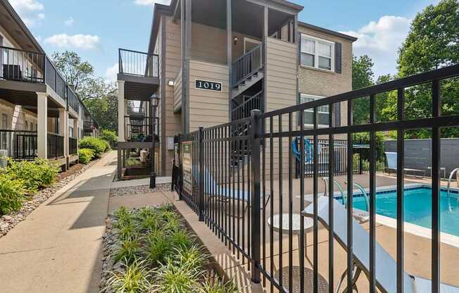 A black metal fence surrounds a small pool.
