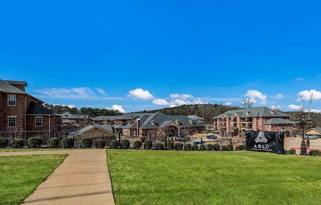 a sidewalk leading to a row of apartments on a green field at Arlo Luxury homes Apartments, Little Rock