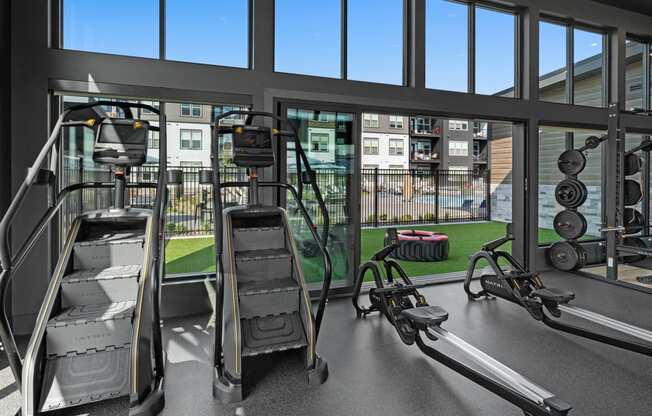 a gym with weights and cardio equipment and a view of a building