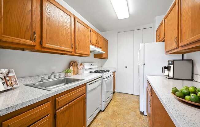 A kitchen with wooden cabinets and a white refrigerator.