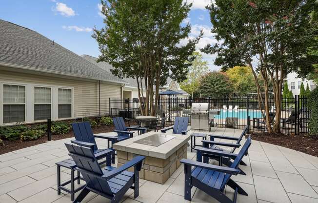 an outdoor patio with blue chairs and a fire pit