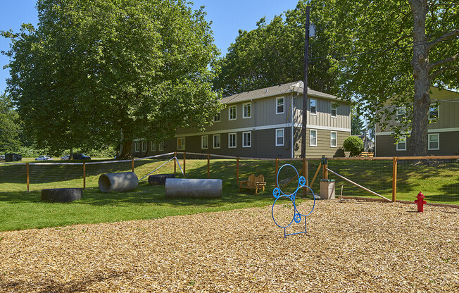 Pet park with training obstacles and wood chips outside of the community.at Woodhaven, Washington