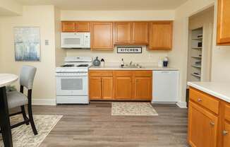 A kitchen with wooden cabinets and a white oven.