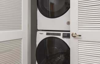 a white front loader washer and dryer in a closet