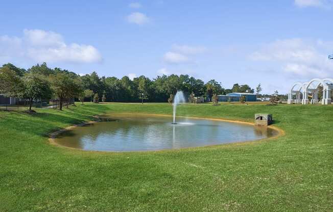 greenspace area with a pond and fountain at Park at Magnolia apartments