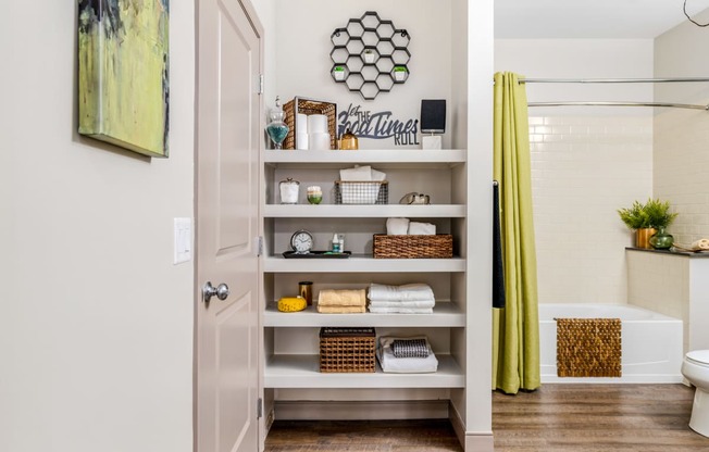 a bathroom with shelves and a shower and a yellow curtain