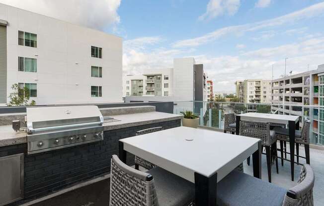 A patio with a table and chairs overlooking a cityscape.