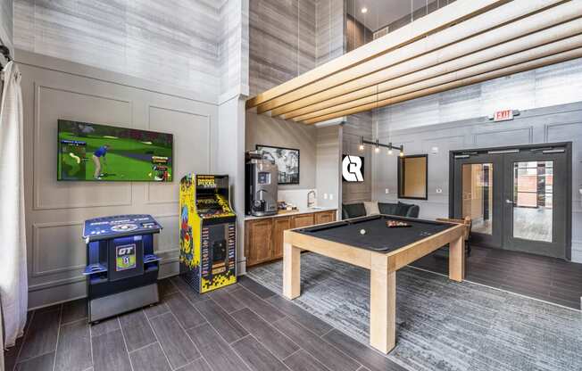 a game room with a pool table and video games and a television