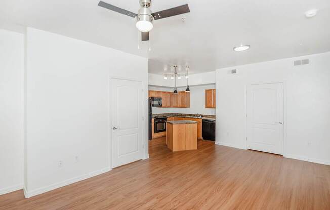 A room with a ceiling fan and wooden floors.