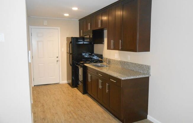 a kitchen with a black stove and a refrigerator