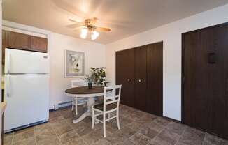 Bismarck, ND Rosser Apartments. A dining room with a table and two chairs. The overhead fan and light brighten the room. The entrance to the unit is next to a large closet for shoes and coats to be hung up.