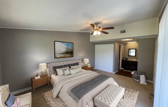 A bedroom with a large bed and a ceiling fan.
