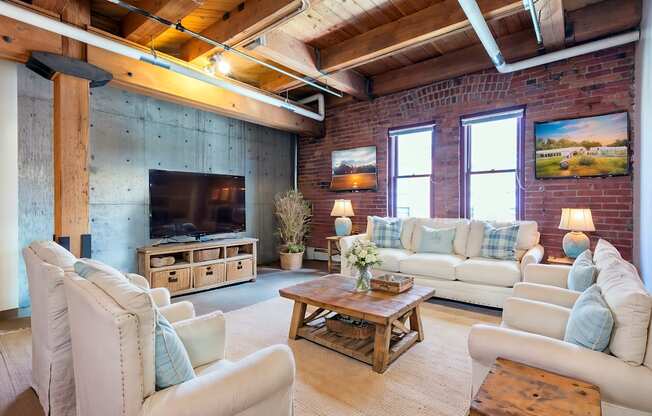 a living room with a brick wall and a television