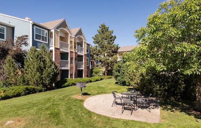 a patio with a table and chairs in front of an apartment building
