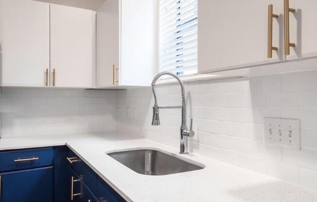 white counter tops with blue cabinets in the kitchen