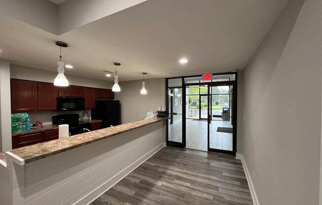 A kitchen with a granite countertop and a view of the outside.