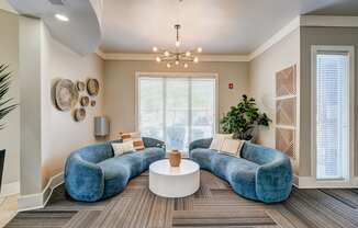 A living room with a blue couch and a white coffee table.