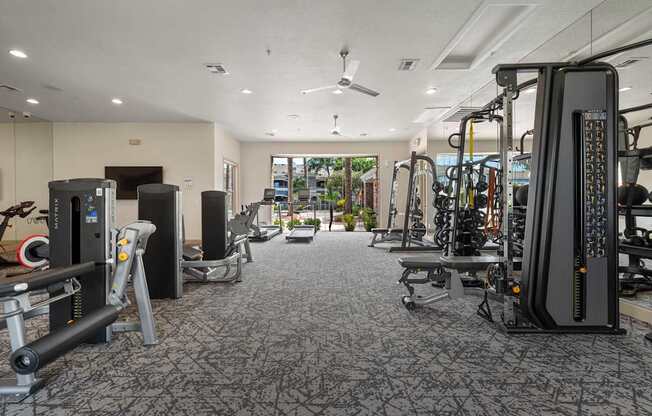 A gym with a variety of equipment including treadmills, weights, and exercise machines.