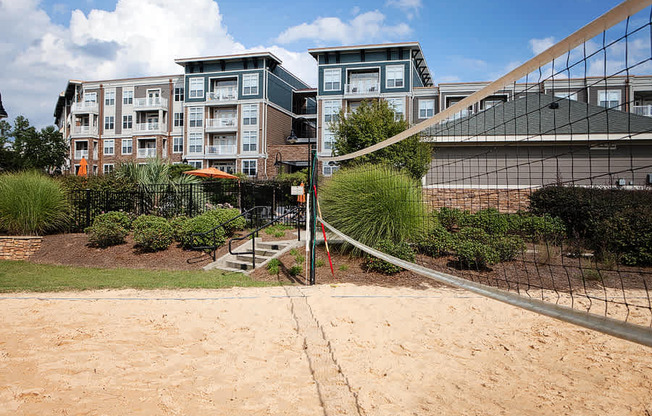 A volleyball net is set up on a sandy court.