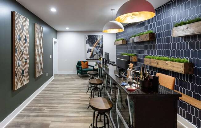a room with a desk and stools in front of a wall with a geometric pattern