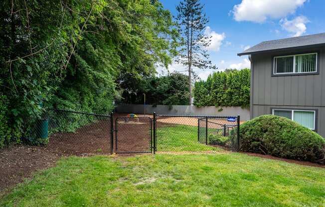 a yard with a fence and a house behind it