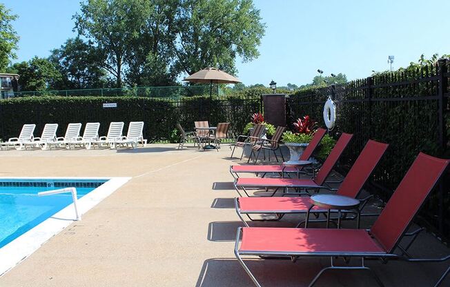 a group of red chairs sitting next to a swimming pool