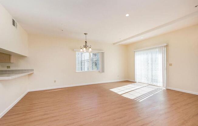 A large empty room with wooden floors and a chandelier.