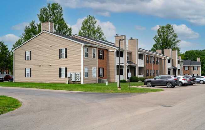 A row of houses with cars parked in front.
