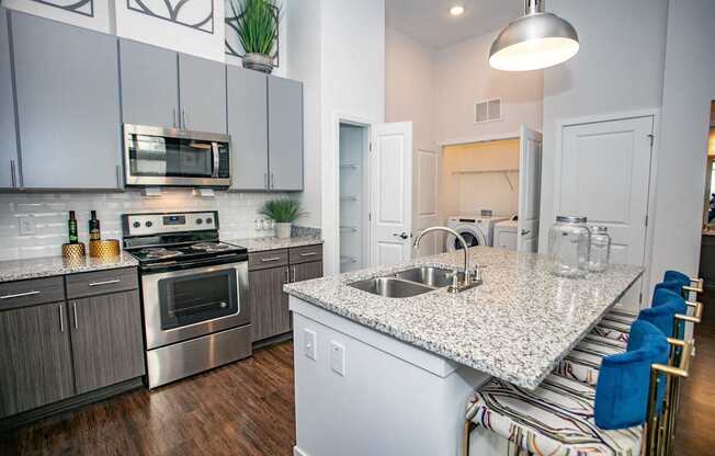 A kitchen with a granite countertop and stainless steel appliances.