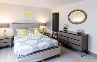 a bedroom with a bed and dresser and a mirror