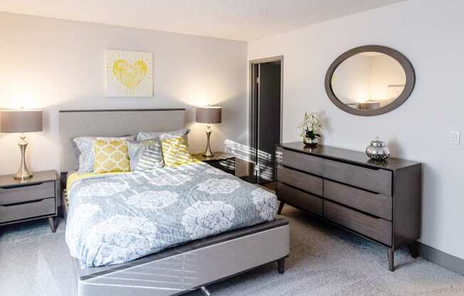 a bedroom with a bed and dresser and a mirror