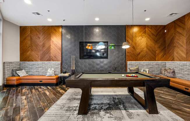 A room with a pool table and a television.