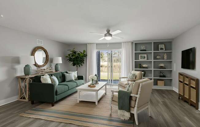 A living room with a green couch, a white coffee table, and a large window with a view of the outside at Mandarin Bay Apartments.