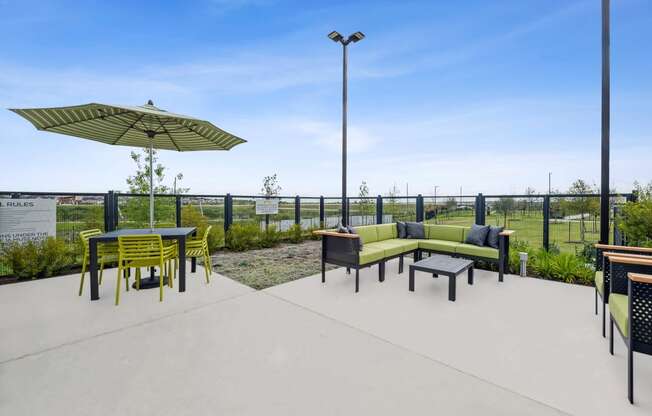 a patio with a table and chairs and an umbrella