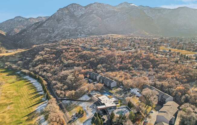 A small town with a river running through it and mountains in the background.