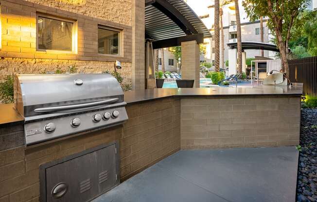 A modern outdoor kitchen with a built-in grill and seating area.