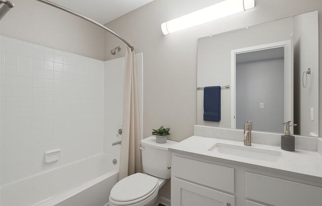 A white bathroom with a toilet, sink, and bathtub.