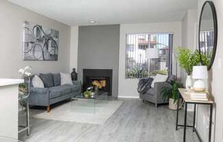 a living room with grey couches and a fireplace