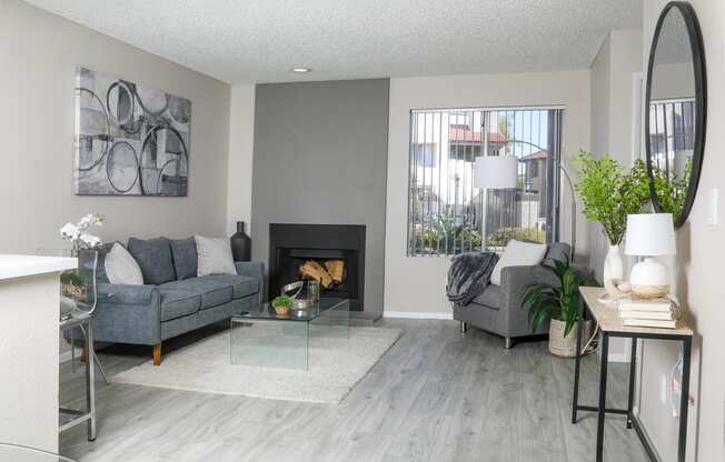 a living room with grey couches and a fireplace