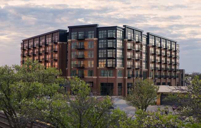 an image of a large apartment building with trees in the foreground