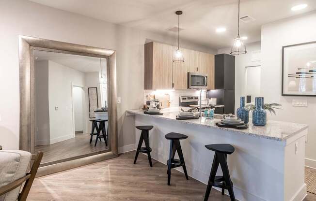 a kitchen with a bar and stools in a house