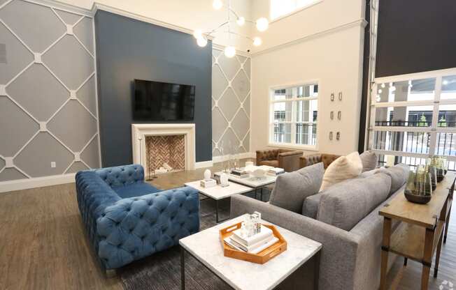 a living room with blue couches and a fireplace at Century Baxter Avenue, Louisville