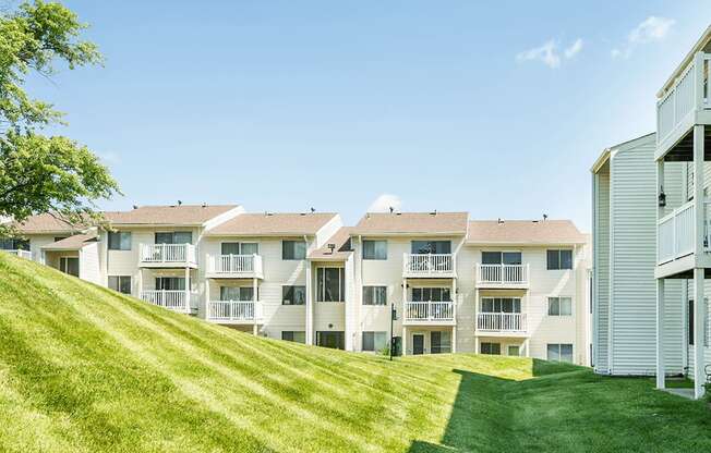 a row of apartment buildings on a grass covered hill