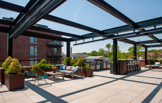 a roof top patio with furniture and a grill