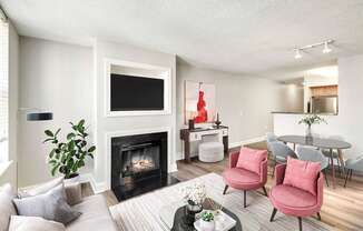 A living room with a fireplace, a TV, and chairs.
