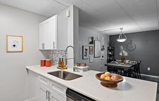 A kitchen with a marble countertop and a bowl of fruit on it.