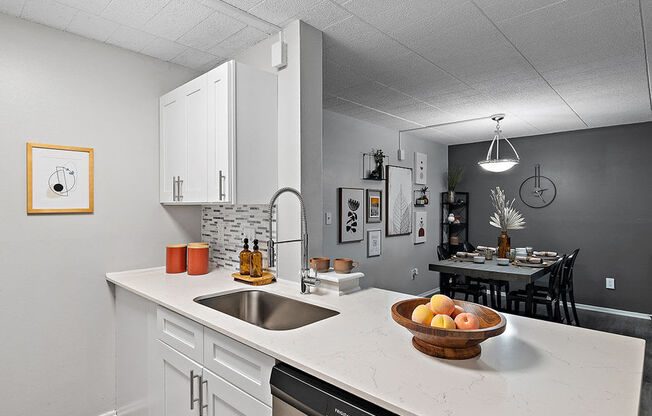 A kitchen with a marble countertop and a bowl of fruit on it.