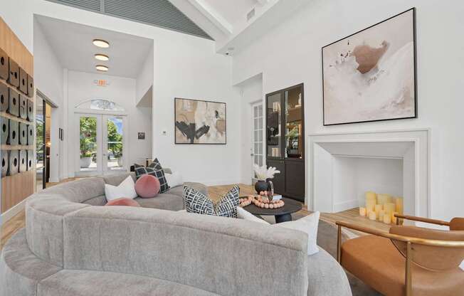A living room with a grey couch and a fireplace.