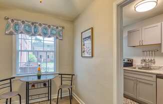 a kitchen with a small table and two chairs next to a window