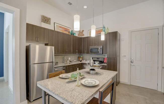 A kitchen with a table set for two with a microwave and oven above at Infinity on the Point Apartments, Dallas, TX, 75243